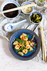 Stir fry with shrimps. Oriental food. Blue plate, chineese bowls.