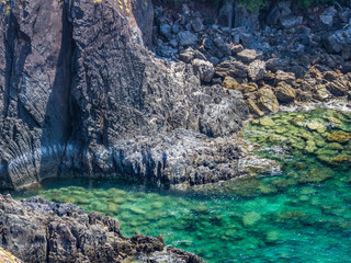 Abstract nature background of clear blue sea and rock coastline.