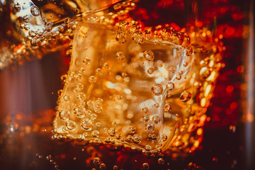 Beautiful cola with ice cubes close up in glass. Shallow DOF.