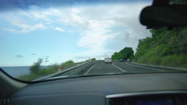 A medium shot of the road with cars while moving on a curvy road