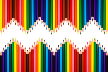 Multiple colored pencils isolated on white and arranged in a zig-zag pattern.