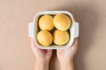 Homemade burger buns in a bowl holding by hand,bread and bakery