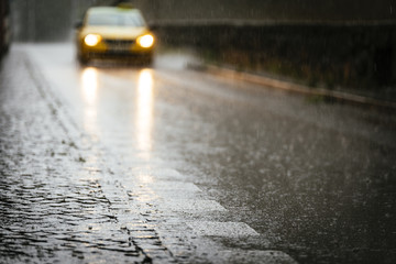 Taxi circulating on wet asphalt while its raining.
