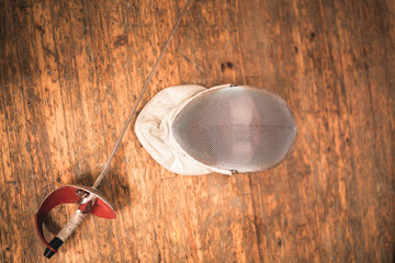 fencing mask and rapier on floor.