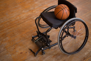 Fototapeta premium Active wheelchair with basketball on wood background