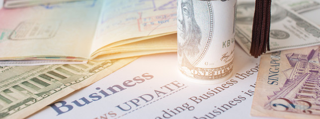 Money and passport with on letter book, Business News update, Concept of graduate education MBA abroad in university, requires a lot foreign currency Dollars to bring success in famous institution