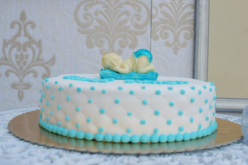 Custom made baby shower or first birthday cake for a boy with sleeping baby topper and cushion-like icing