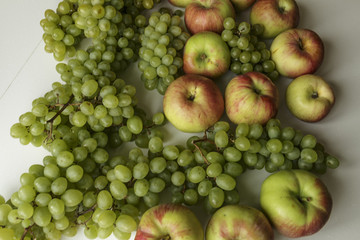 Vegan food. Fresh green grapes bunches and apples, isolated on white background