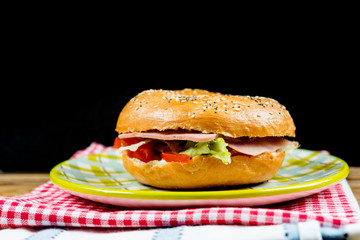 Bagel with fresh cheese and fresh lettuce on napkin