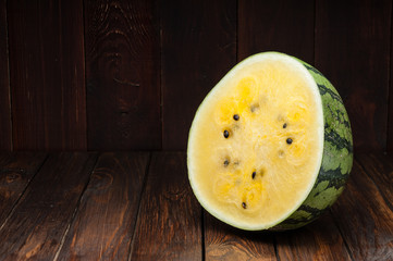 yellow watermelon slices on dark old wooden background