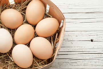 chicken egg in a straw nest on white old wood  background