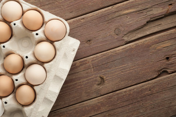 chicken eggs in cardboard box on dark wooden background