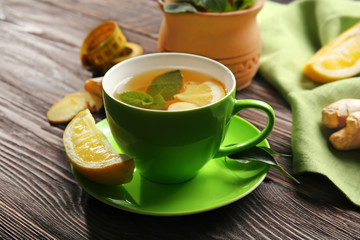 Cup of tea with lemon and ginger on wooden table. Weight loss concept