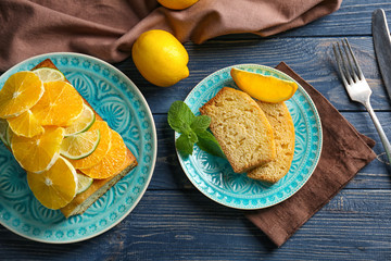 Delicious sliced cake and mint leaves on wooden table