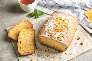 Delicious sliced citrus cake on grey table