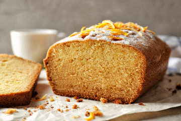 Closeup view of delicious sliced citrus cake on grey table