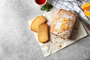 Delicious sliced citrus cake on grey table