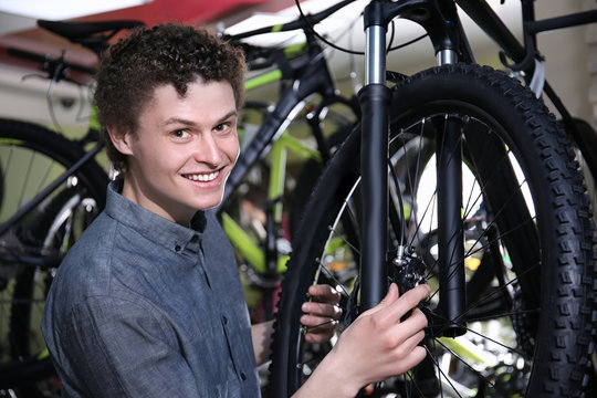 Young man choosing bicycle in shop