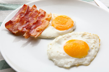 Plate with fried eggs and bacon, closeup