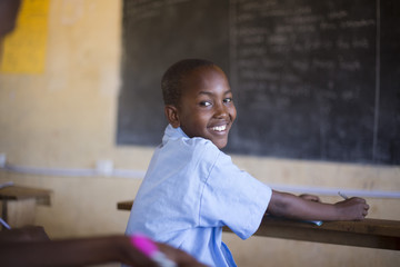 Smiling school boy in classroom. Kenya, Africa.