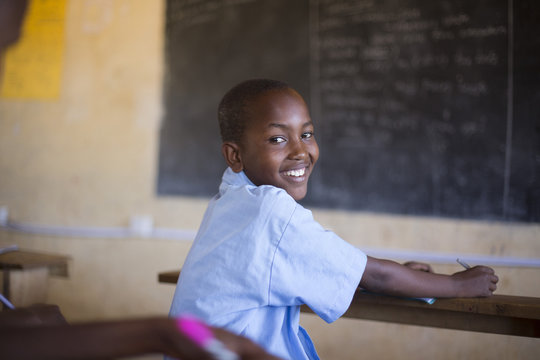 Smiling school boy in classroom. Kenya, Africa.