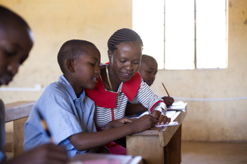 Teacher with students in classroon. Kenya, Africa.