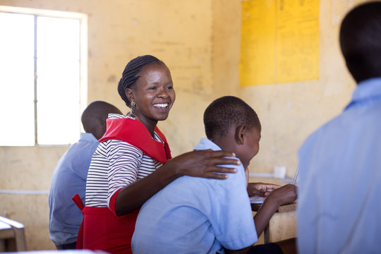 Female teacher with studentsin classroom. Kenya, Africa.