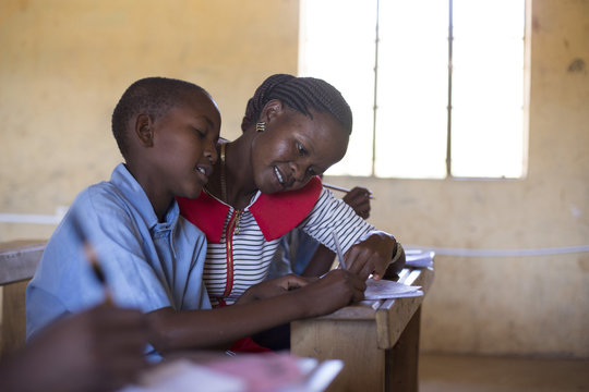Teacher teaching in classroom with school children. Kenya, Africa.