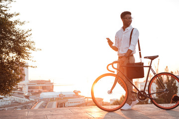 African man early morning standing near bicycle