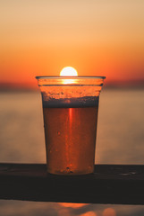 One beer cup with setting sun in the background