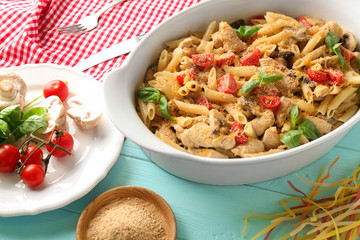 Baking dish with delicious turkey tetrazzini and ingredients on table