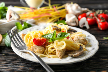 Plate with delicious turkey tetrazzini and fork on table