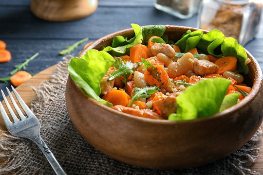 Bowl with delicious carrot salad on table, closeup