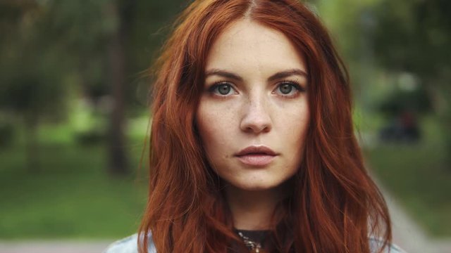 sensual closeup portrait of beautiful red-haired girl in a summer Park. 20s