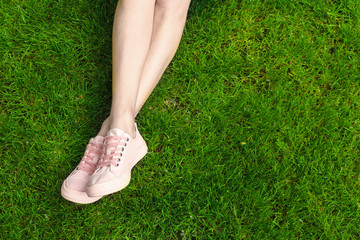 Beautiful female legs on green grass background