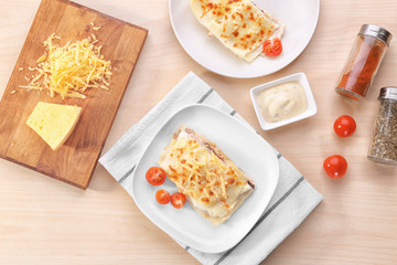 Composition with tasty lasagna, cheese and tomatoes on wooden table