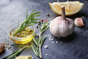 Store enrouleur Herbes Composition with fresh rosemary, oil, garlic and lemon on table