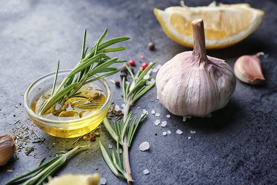 Composition with fresh rosemary, oil, garlic and lemon on table