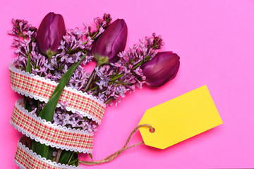 Yellow price tag for bunch of lilac flowers and tulips