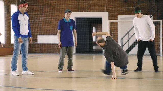 Breakdancer dances in front of his friends