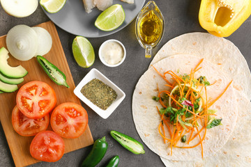 Fish taco with filling and ingredients on grey background