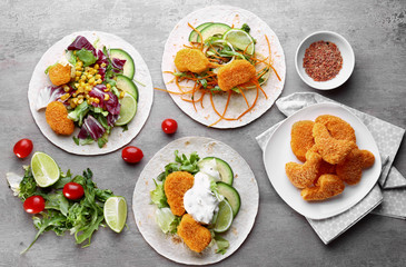 Different fish tacos with filling on grey background