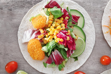 Delicious fish taco with filling on table, close up