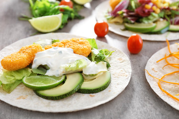 Delicious fish taco with filling on table, close up