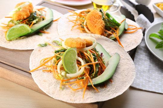 Fish tacos with filling on wooden background