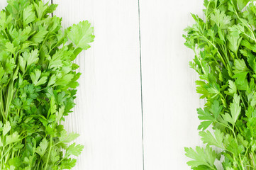 Two lines of green fresh raw parsley on old white wooden rustic planks