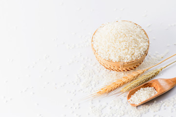 raw rice in a bamboo basket with wheat isolated on white background