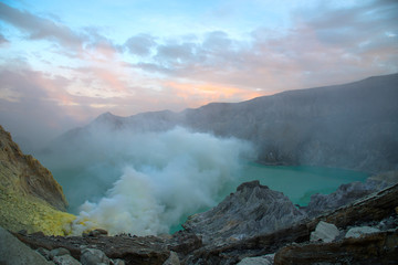 Sulfuric acidic big lake and mountains Kawah Ijen Volcano crater,many people, tourism on top of crater popular,landmark famous travel destinations Indonesian, Fog and smoke on mountain at sunrise.
