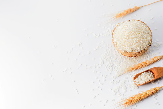 raw rice in a bamboo basket with wheat isolated on white background