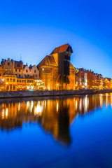 Fototapeta premium Gdansk at night with reflection in Motlawa river, Poland